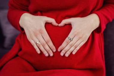 Hamile kadın karnına sarılıyor.