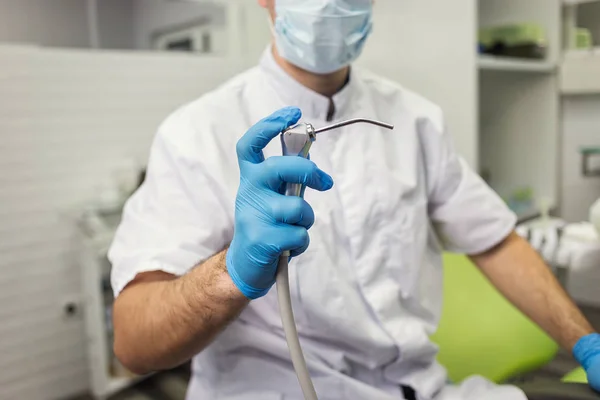 Dentista masculino com ferramentas sobre o fundo do consultório médico. Saúde, profissão, estomatologia e medicina conceito — Fotografia de Stock