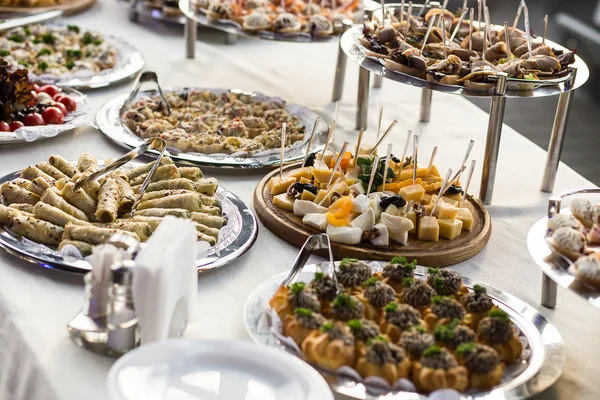 Meja prasmanan hari libur yang disajikan oleh berbagai macam canape, roti lapis, makanan ringan yang siap untuk dimakan di restoran — Stok Foto