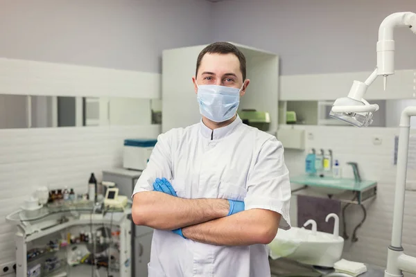 Manliga tandläkare står med händerna korsade över medicinsk kontor bakgrund. Hälso-och sjukvård, yrke, Stomatologi och medicin koncept — Stockfoto