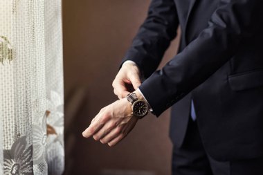 İş adamı ceket giyiyor, erkek eli kapalı, damat düğün töreninden önce hazırlanıyor.