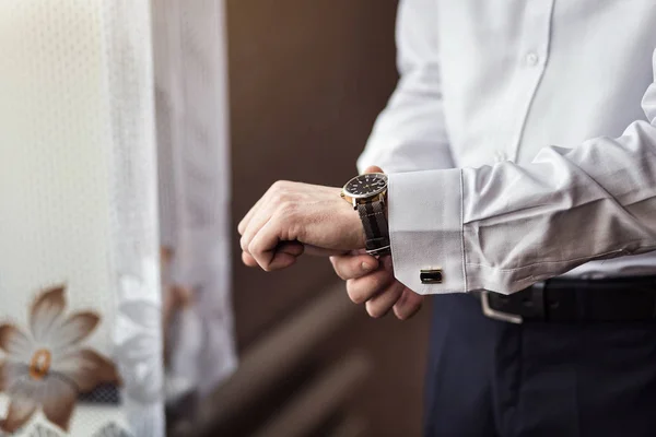 Biznesmen sprawdzający czas na zegarku, mężczyzna wkładający zegar do ręki, pan młody szykujący się rano przed ślubem — Zdjęcie stockowe