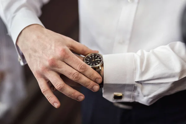 Hombre de negocios comprobar la hora en su reloj de pulsera, hombre poniendo reloj en la mano, novio preparándose en la mañana antes de la ceremonia de boda — Foto de Stock