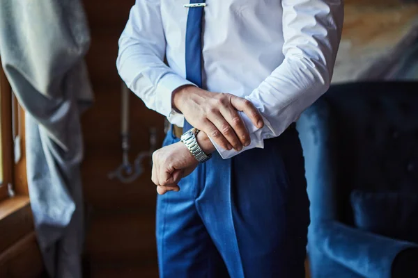 Affärsman kollar tiden på handleden, man sätter klockan på hand, brudgummen gör sig redo på morgonen före bröllopsceremonin. Män mode — Stockfoto
