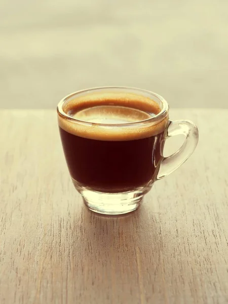 Cup of hot espresso coffee on wooden table — Stock Photo, Image