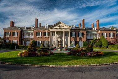 Glen Cove 'daki Konak (asıl adıyla The Manor) 1910 yılında ünlü mimar Charles Adams Platt tarafından tasarlanmıştır. Malikane John Teele ve Ruth Baker Pratt 'in eviydi. John Pratt, John D. Rockefeller 'ın avukatı ve yöneticisiydi.