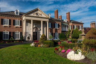 Glen Cove 'daki Konak (asıl adıyla The Manor) 1910 yılında ünlü mimar Charles Adams Platt tarafından tasarlanmıştır. Malikane John Teele ve Ruth Baker Pratt 'in eviydi. John Pratt, John D. Rockefeller 'ın avukatı ve yöneticisiydi.