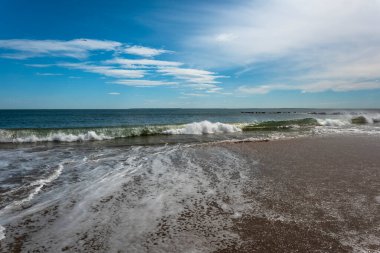 Güneşli bir bahar gününde Brighton Sahili 'nde okyanus dalgalarını dinlemek.