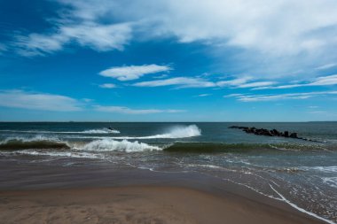 Güneşli bir bahar gününde Brighton Sahili 'nde okyanus dalgalarını dinlemek.