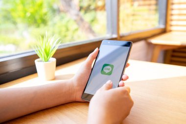 CHIANG MAI, THAILAND - 19 Ocak 2019: HUAWEI 'yi ekrana bağlayan kadın. LINE ücretsiz sesli arama yapmanızı ve ücretsiz mesaj göndermenizi sağlayan yeni bir iletişim uygulaması.