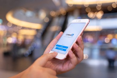 CHIANG MAI, THAILAND - 10 Mayıs 2019: Elma iPhone 6S Rose Gold 'u tutan ve ekranda Linkedin uygulaması olan kadın. Linkedin bir iş ve istihdam odaklı sosyal ağ hizmetidir..