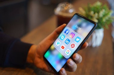 CHIANG MAI, THAILAND - Mar. 24,2019: Xiaomi Mi Mix 3 'ü elinde tutan adam ve sosyal medya simgeleri ekranda. Sosyal medya en popüler araçtır. Akıllı telefon yaşam tarzı. Sosyal medya uygulaması başlatılıyor.