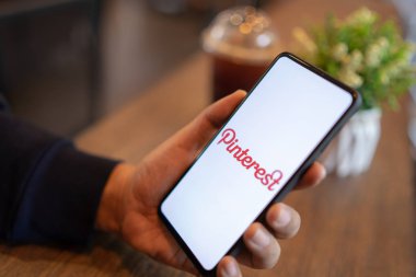 Chiang Mai, Tayland - Mar. 24,2019: Xiaomi Mi Mix 3 cep telefonunu elinde bulunduran ve Pinterest uygulamalarıyla ekranda oturum aç. Pinterest, insanların ilginç şeyleri sabitlemelerine olanak tanıyan çevrimiçi bir pinboard.