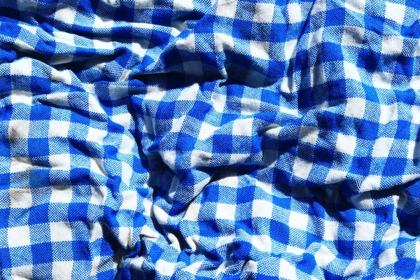 Blue checkered fabric. Blue and white checkered fabric. Textiles for plaid, tablecloths, clothes, shirts, dresses. A sample of blue fabric close-up