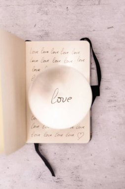 Defter aşk sözcüğüyle dolu, lens topu.