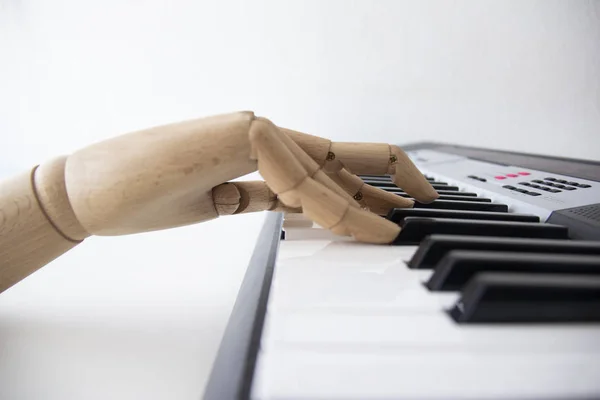 Una mano de madera tocando un teclado electrónico Fotos De Stock