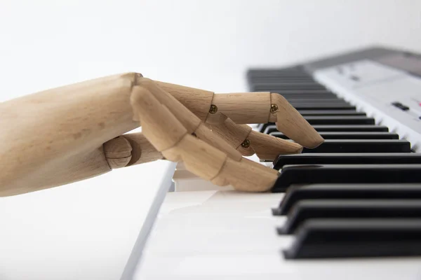 Una mano de madera tocando un teclado electrónico Imágenes De Stock Sin Royalties Gratis