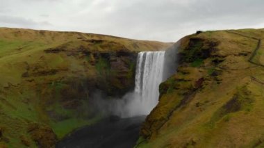 İzlanda 'nın güneyindeki Skogafoss Şelalesi yakınlarında uçuyor. Yüksek su çağlayanı ve renkli gökkuşağı aparatı. Seyahat