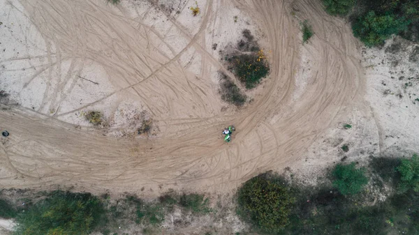 A motorcyclist on a sandy road. Aerial view.