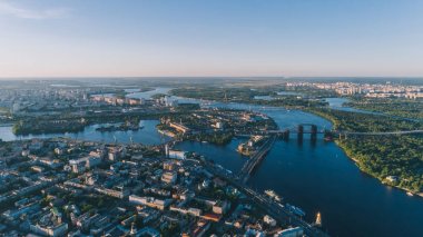 Dinyeper Nehri'nin havadan görünümü. Köprüler. Panorama. Birçok bina. Ufuk. Güneş parlıyor. Bir gün. Yaz. Trukhanov Adası. Orman. Ağaçlar. Kiev. Ukrayna. Doğa.