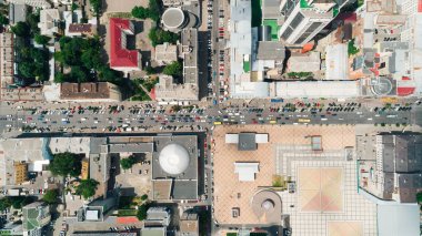 Hangi araba gidiyorsun yolun yükseklikten görüntüleyin. Tıkamak. Kiev şehir. Yaz. Güneş parlıyor. Bir gün. Ağaçlar. Şehir sokaklarını. Arabanın hava görünümünü. Kiev. Kavşak.