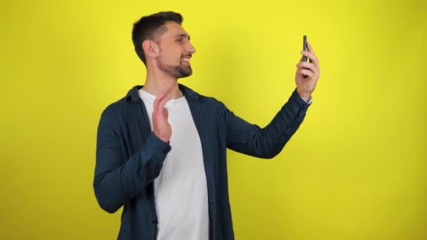 Young Blogger Blue Shirt White Shirt Broadcasting Smartphone Yellow Background — Stock Video