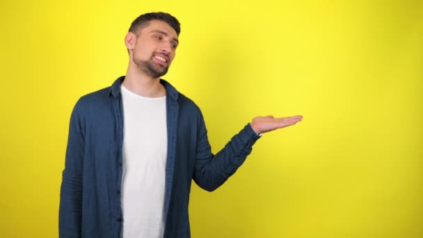 Jeune Homme Chemise Bleue Shirt Blanc Regarde Caméra Tient Objet — Video