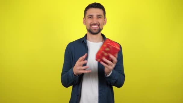 Joven Con Una Camiseta Blanca Lanza Una Caja Con Regalo — Vídeo de stock