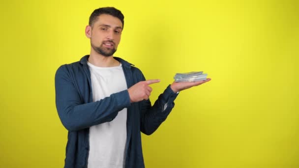 Beyaz Tişörtlü Genç Bir Adam Parmağıyla Avucundaki Banknotları Işaret Ediyor — Stok video
