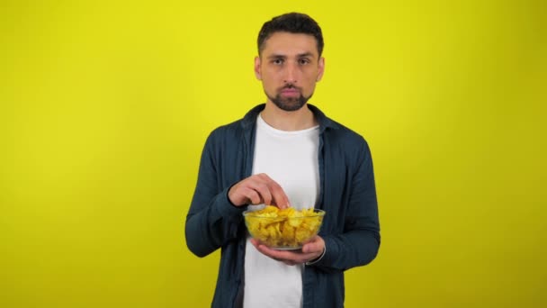 Mladý Muž Modré Košili Bílém Tričku Dívá Kamery Chipsy Průhledného — Stock video