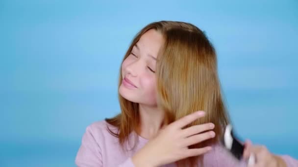 Fröhliches Teenie Mädchen Rosa Pullover Kämmt Ihr Haar Mit Einem — Stockvideo