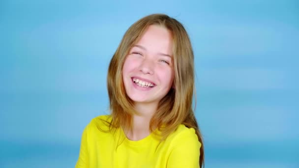 Щаслива Дівчина Підліток Жовтій Футболці Сміється Дивиться Камеру Синій Фон — стокове відео