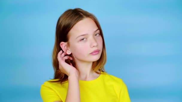 Glad Tonårstjej Gul Shirt Rätar Håret Med Ena Handen Poserar — Stockvideo