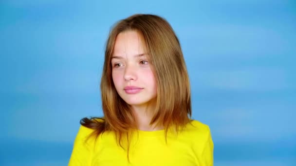 Teen Ragazza Una Shirt Gialla Sta Guardando Lontano Sfondo Blu — Video Stock