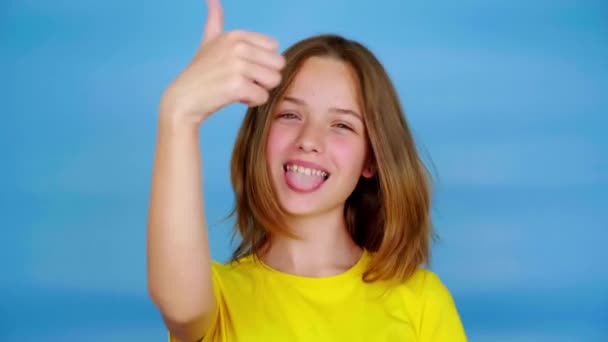Menina Adolescente Feliz Uma Camiseta Amarela Mostra Língua Polegares Para — Vídeo de Stock