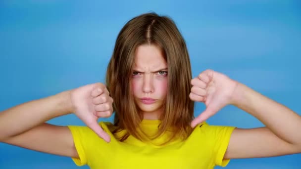Menina Adolescente Irritada Uma Camiseta Amarela Está Mostrando Polegares Para — Vídeo de Stock