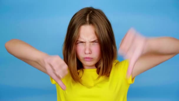 Menina Adolescente Irritada Uma Camiseta Amarela Está Mostrando Polegares Para — Vídeo de Stock