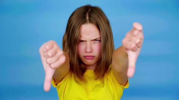 Menina Adolescente Irritada Uma Camiseta Amarela Está Mostrando Polegares Para — Vídeo de Stock