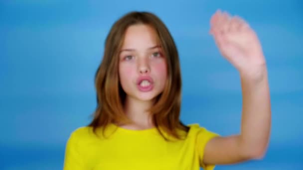 Дівчина Підліток Жовтій Футболці Дивиться Камеру Тримає Руку Спереду Каже — стокове відео