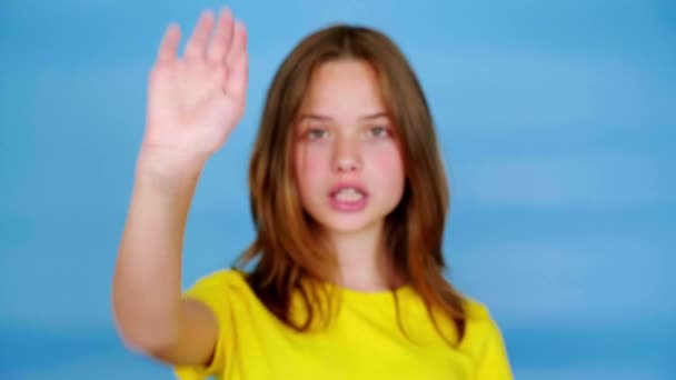 Menina Adolescente Uma Camiseta Amarela Olha Para Câmera Estende Mão — Vídeo de Stock