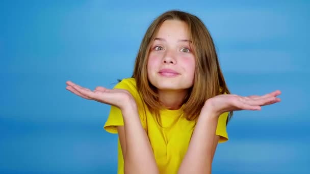 Teen Girl Yellow Shirt Shrugs Turns Her Head Looking Camera — Stock Video