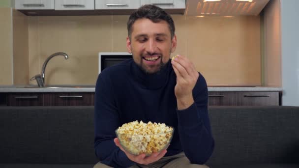 Mladý Muž Tmavomodrém Svetru Šedých Kalhotách Sedí Gauči Popcorn Průhledného — Stock video