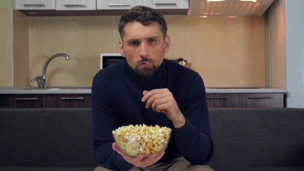 Vážný Mladý Muž Tmavomodrém Svetru Šedých Kalhotách Sedících Gauči Popcorn — Stock video