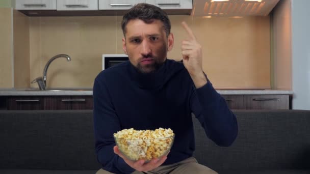 Vážný Mladý Muž Tmavomodrém Svetru Šedých Kalhotách Sedících Gauči Popcorn — Stock video