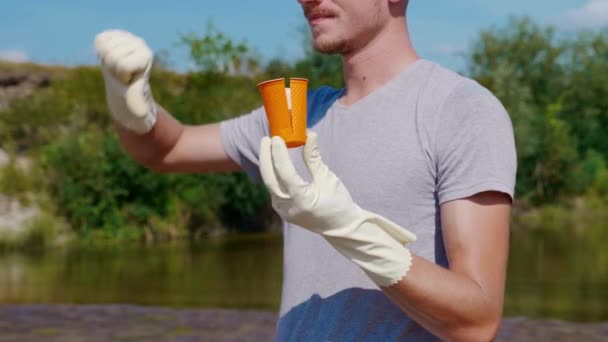 Detailní záběr muže, který drží plastové odpadky a ukazuje nelibost. — Stock video