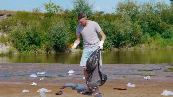 L'homme est recueille des déchets en plastique et montre pouces vers le haut . — Video