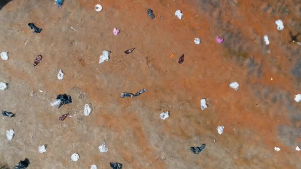Vue aérienne du dessus des déchets plastiques jetés sur les rives d'une rivière sèche et polluée — Video