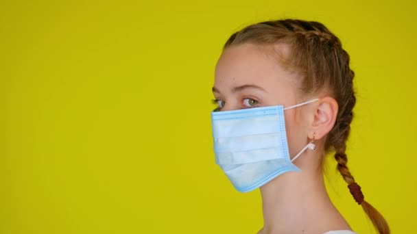Μια Έφηβη Ιατρική Μάσκα Γυρίζει Κεφάλι Της Στην Κάμερα Επιδημικές — Αρχείο Βίντεο