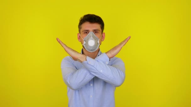 Man in protective mask looks at camera and keeps his arms crossed — Stock video