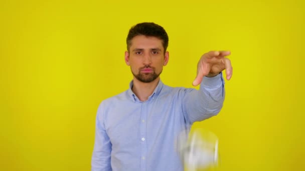 Молодой человек бросает защитную маску на пол на желтом фоне — стоковое видео